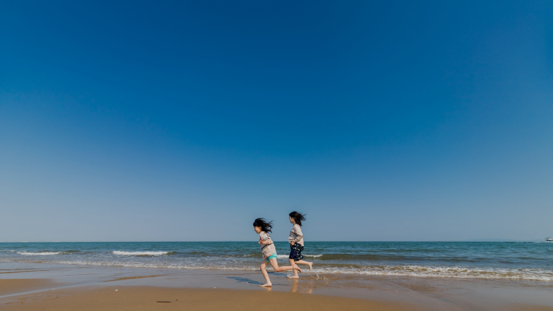 海辺を走る子どもたち